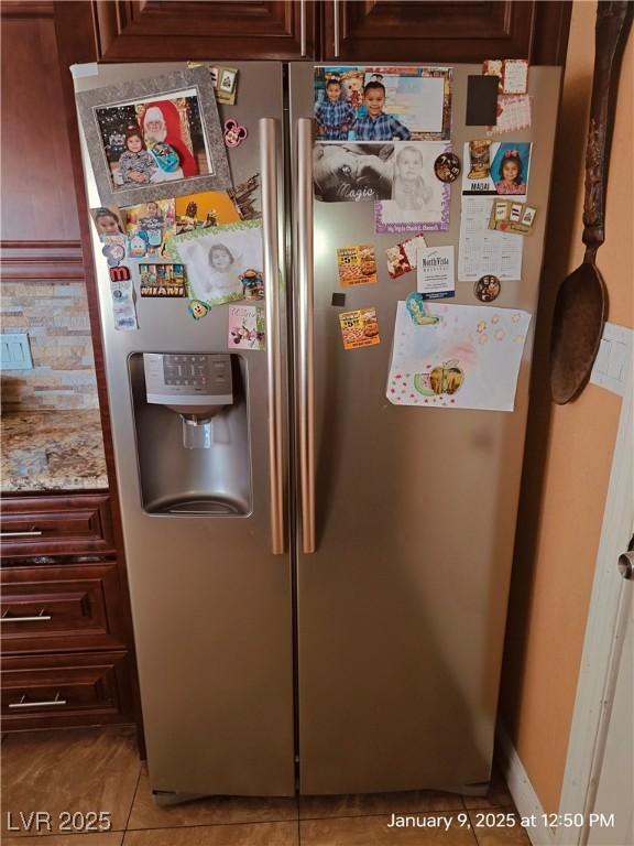 interior details with stainless steel fridge with ice dispenser and dark brown cabinets