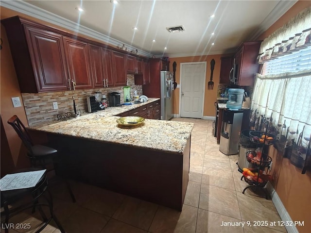 kitchen featuring kitchen peninsula, appliances with stainless steel finishes, decorative backsplash, light stone countertops, and light tile patterned flooring