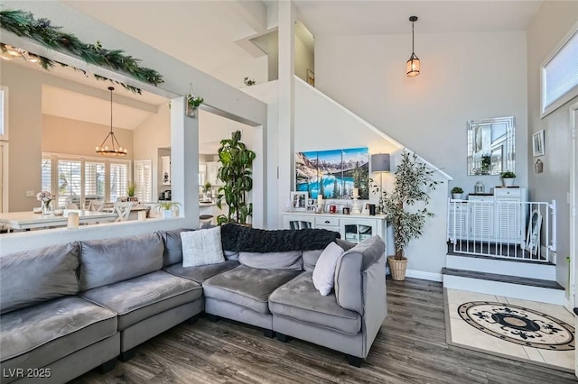 living room featuring dark hardwood / wood-style floors, high vaulted ceiling, and a notable chandelier