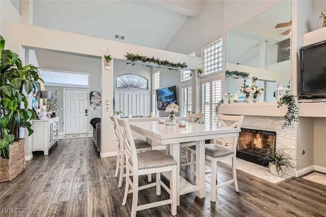 dining room featuring beamed ceiling, dark wood-type flooring, and high vaulted ceiling