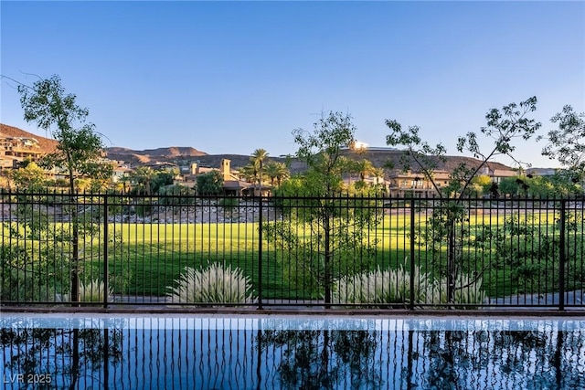 view of swimming pool with a lawn and a mountain view