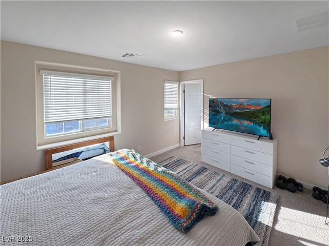 bedroom with light carpet and multiple windows