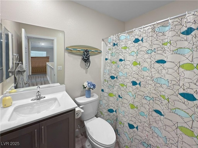 bathroom featuring curtained shower, vanity, and toilet