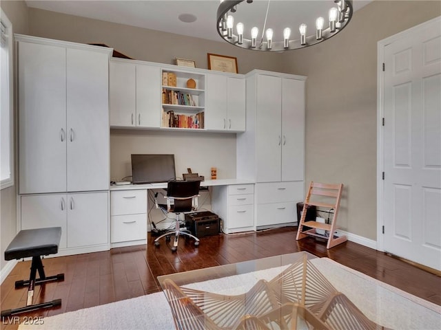 home office featuring dark wood-type flooring and an inviting chandelier