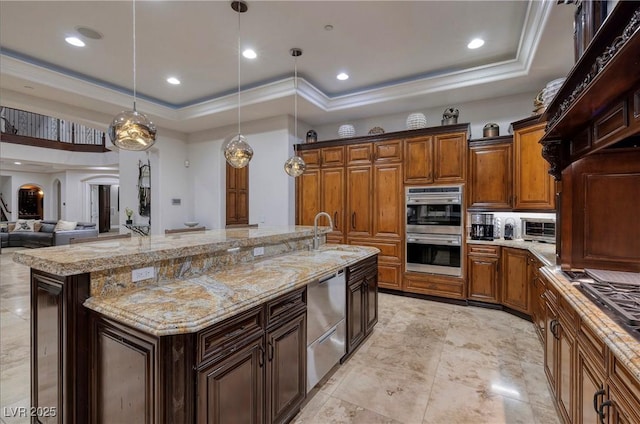 kitchen with sink, stainless steel appliances, pendant lighting, a spacious island, and a tray ceiling