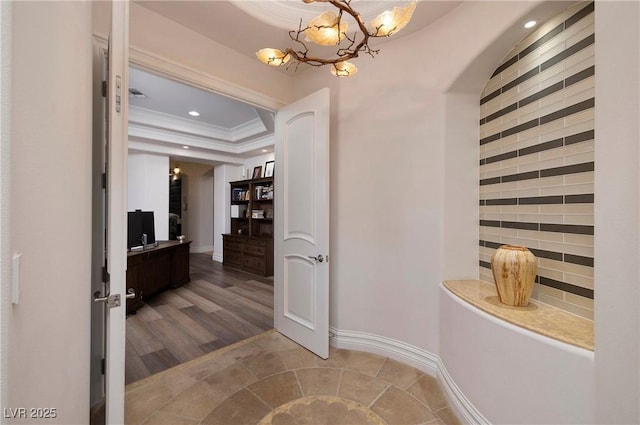 bathroom with a raised ceiling, hardwood / wood-style flooring, a notable chandelier, and ornamental molding