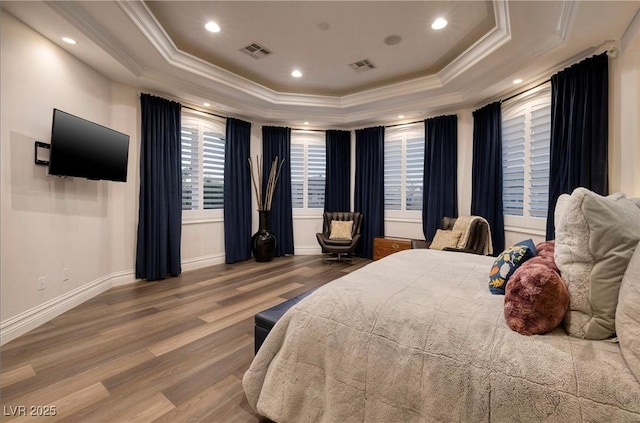 bedroom featuring a raised ceiling, crown molding, and wood-type flooring