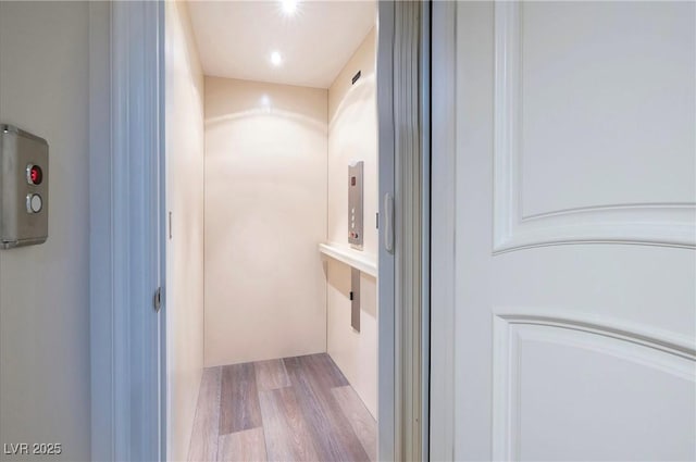 bathroom with hardwood / wood-style floors and elevator