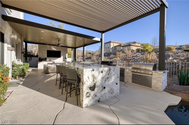 view of patio / terrace with an outdoor kitchen, area for grilling, exterior bar, and ceiling fan