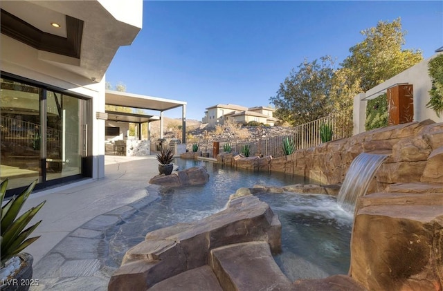 view of pool featuring a patio, pool water feature, and a hot tub