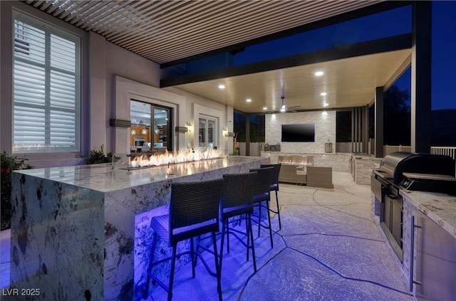 view of patio / terrace with ceiling fan, exterior bar, and an outdoor kitchen