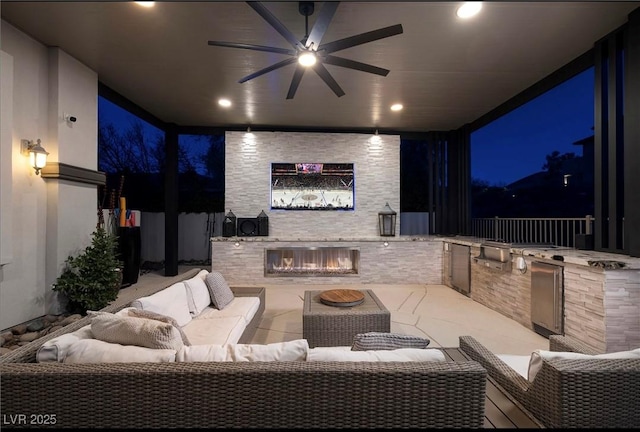 patio at night featuring an outdoor living space with a fireplace