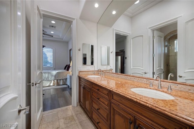 bathroom featuring tile patterned flooring, vanity, crown molding, and walk in shower