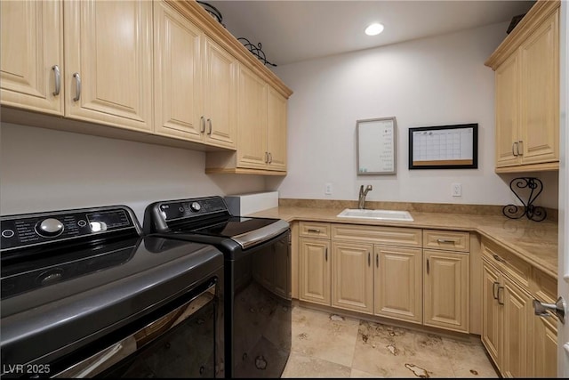 clothes washing area with cabinets, washer and clothes dryer, and sink