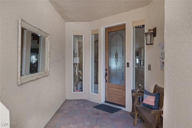 doorway to property featuring stucco siding