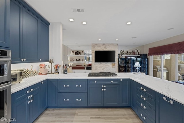 kitchen featuring visible vents, open floor plan, a peninsula, blue cabinetry, and stainless steel gas stovetop