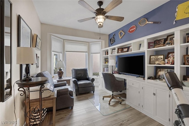 office with a ceiling fan, light wood-type flooring, and built in desk