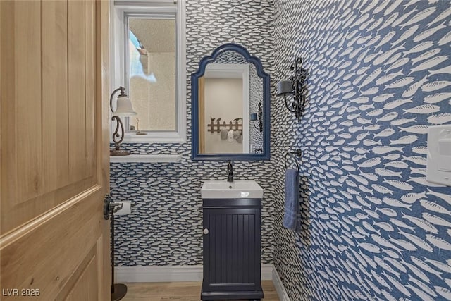 bathroom featuring vanity, baseboards, and wood finished floors