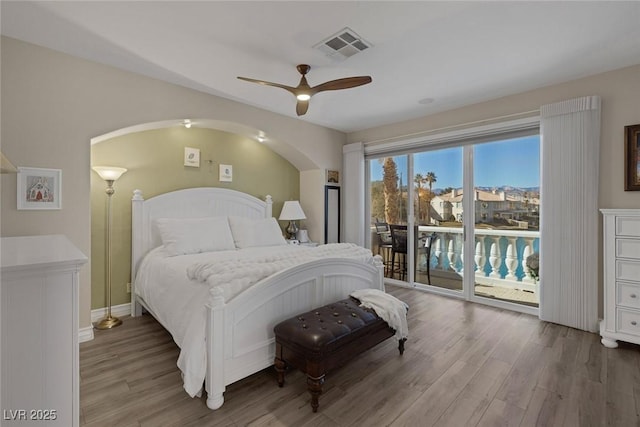 bedroom featuring a ceiling fan, access to outside, visible vents, and wood finished floors