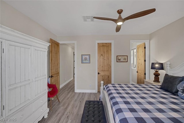 bedroom featuring baseboards, a ceiling fan, visible vents, and light wood-style floors