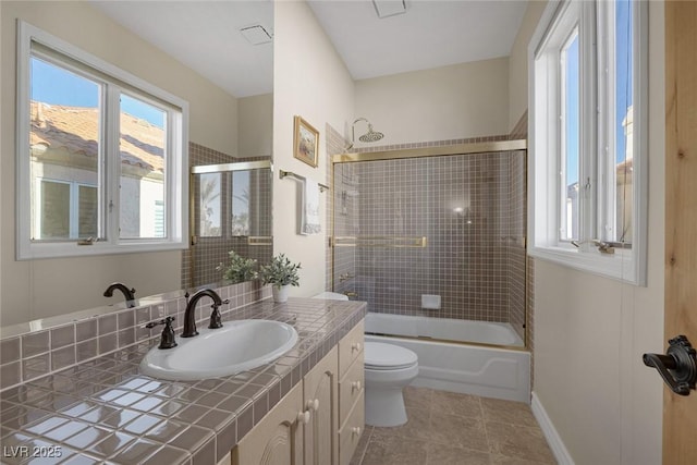 full bathroom featuring toilet, shower / bath combination with glass door, vanity, baseboards, and tile patterned floors