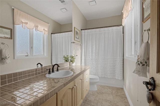 bathroom with visible vents, shower / bathtub combination with curtain, toilet, vanity, and baseboards