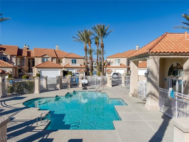 community pool featuring a patio, fence, and a residential view