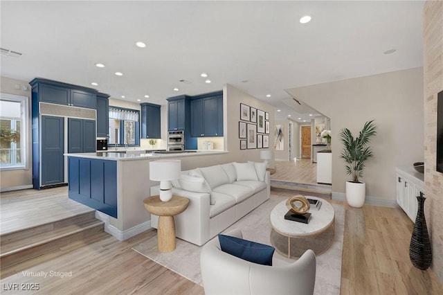 living area with light wood-type flooring, plenty of natural light, and visible vents