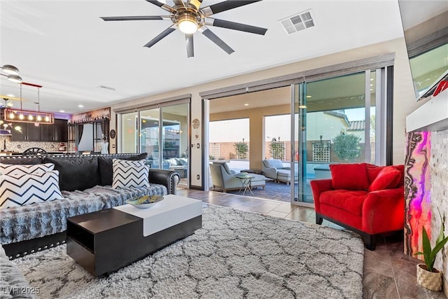 living area featuring visible vents and ceiling fan