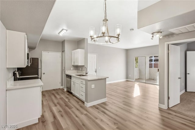 kitchen with visible vents, light countertops, stainless steel dishwasher, white cabinetry, and a sink