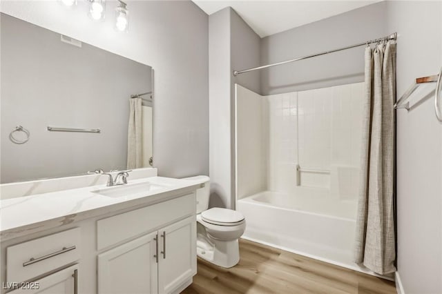 bathroom featuring toilet, shower / tub combo with curtain, wood finished floors, and vanity