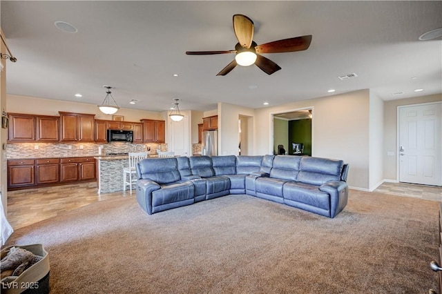 carpeted living room with ceiling fan