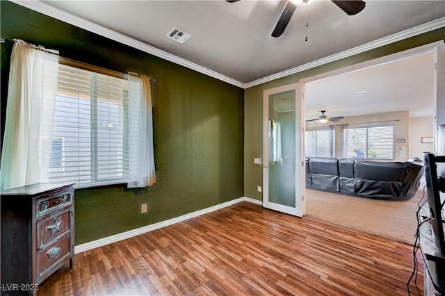 spare room with wood-type flooring, ceiling fan, and crown molding