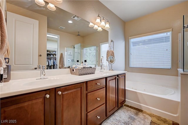 bathroom featuring vanity and independent shower and bath