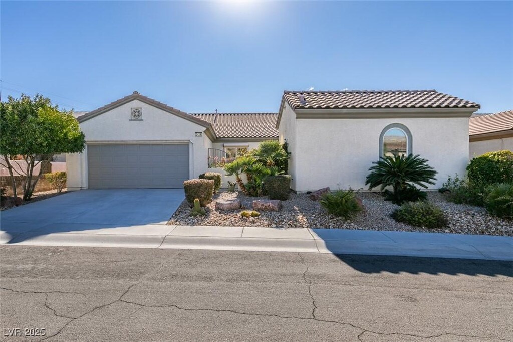 2429 Anderson Park Dr, Henderson, NV 89044 - mediterranean / spanish house with concrete driveway, an attached garage, a tile roof, and stucco siding