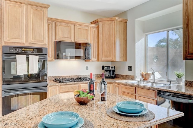 kitchen featuring light brown cabinetry, light stone counters, sink, and black appliances