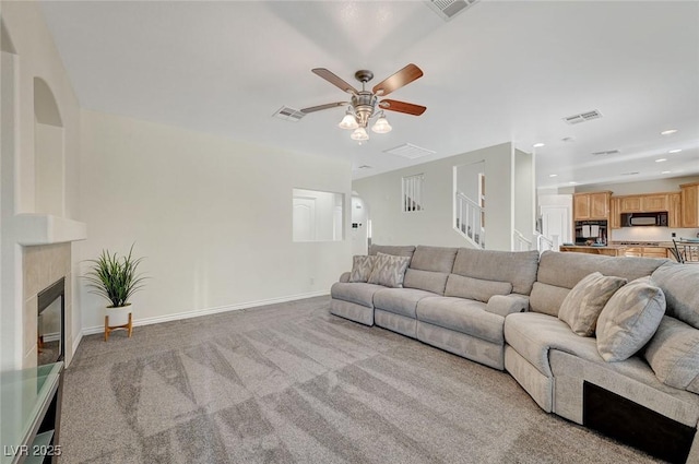 carpeted living room with ceiling fan