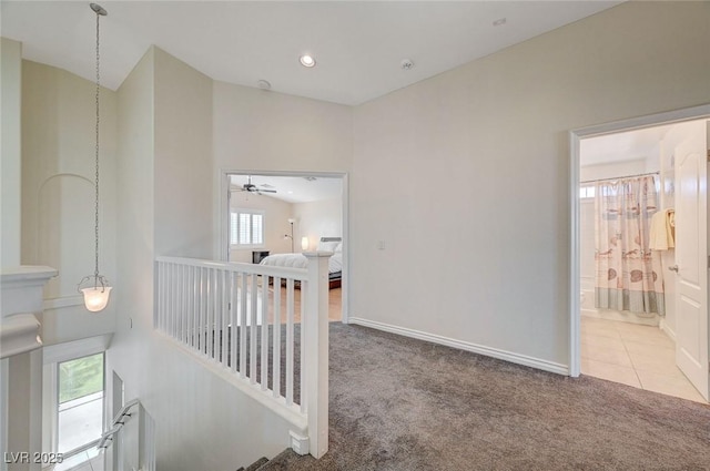 hallway with carpet floors and vaulted ceiling