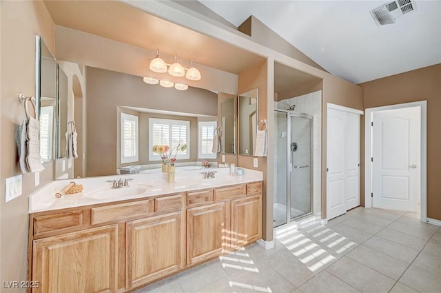 bathroom with tile patterned flooring, vanity, vaulted ceiling, and walk in shower