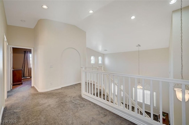 corridor with carpet flooring and vaulted ceiling