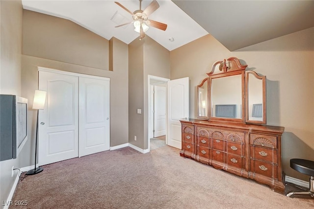 bedroom featuring ceiling fan, a closet, carpet, and vaulted ceiling