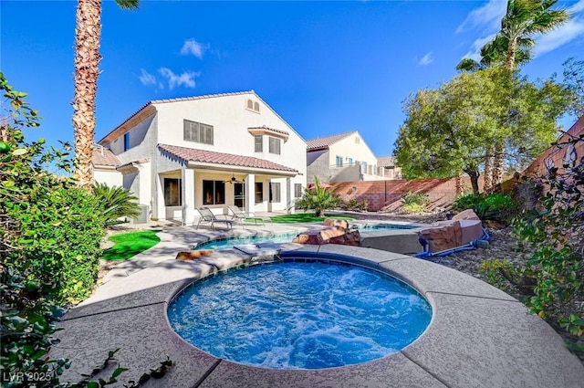 back of property featuring a pool with hot tub, ceiling fan, and a patio