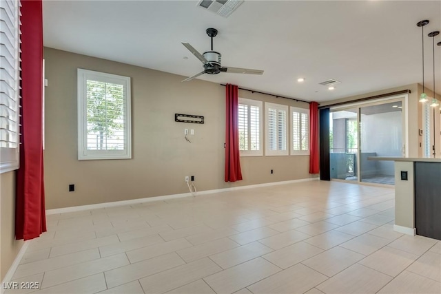 tiled empty room with plenty of natural light and ceiling fan