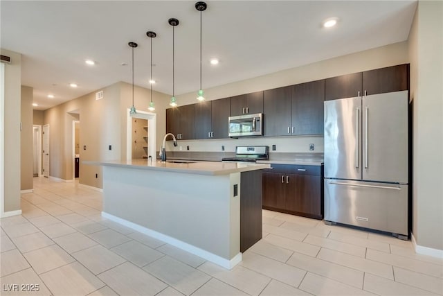 kitchen with sink, hanging light fixtures, dark brown cabinets, a center island with sink, and appliances with stainless steel finishes