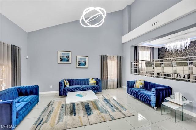 living room featuring a towering ceiling, light tile patterned floors, and an inviting chandelier