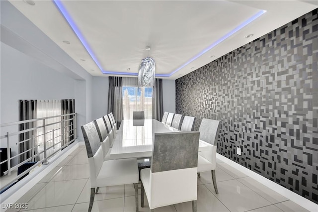 dining room with a raised ceiling, light tile patterned flooring, and an inviting chandelier