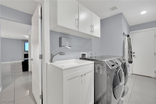 laundry room featuring cabinets, sink, light tile patterned floors, and washer and dryer