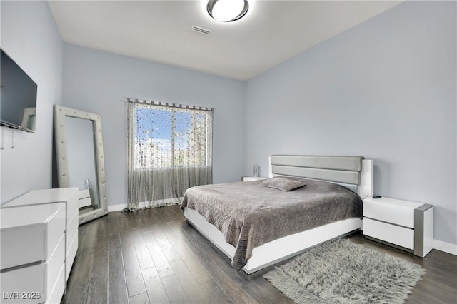 bedroom with dark hardwood / wood-style floors