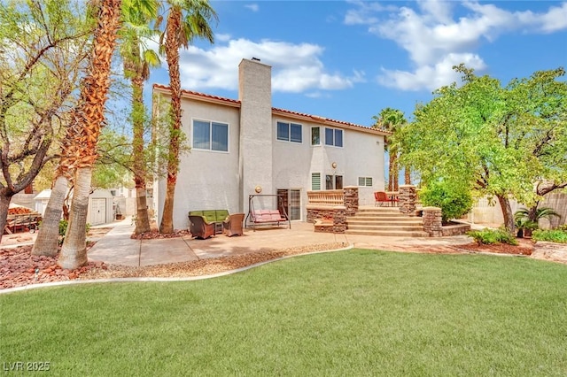 rear view of property with a lawn, a patio area, and a storage shed