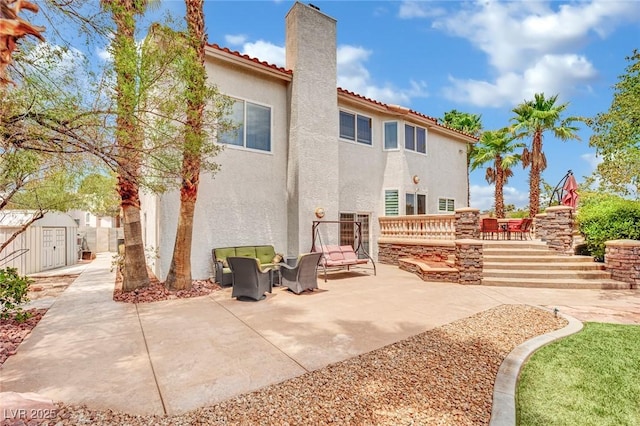 rear view of property with a patio and a shed